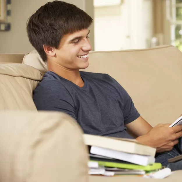 Young Person Doing Homework On The Sofa