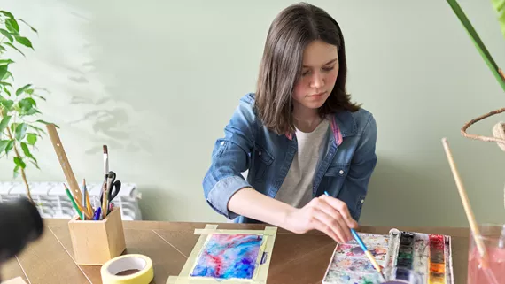 Young Person Painting On The Kitchen Table